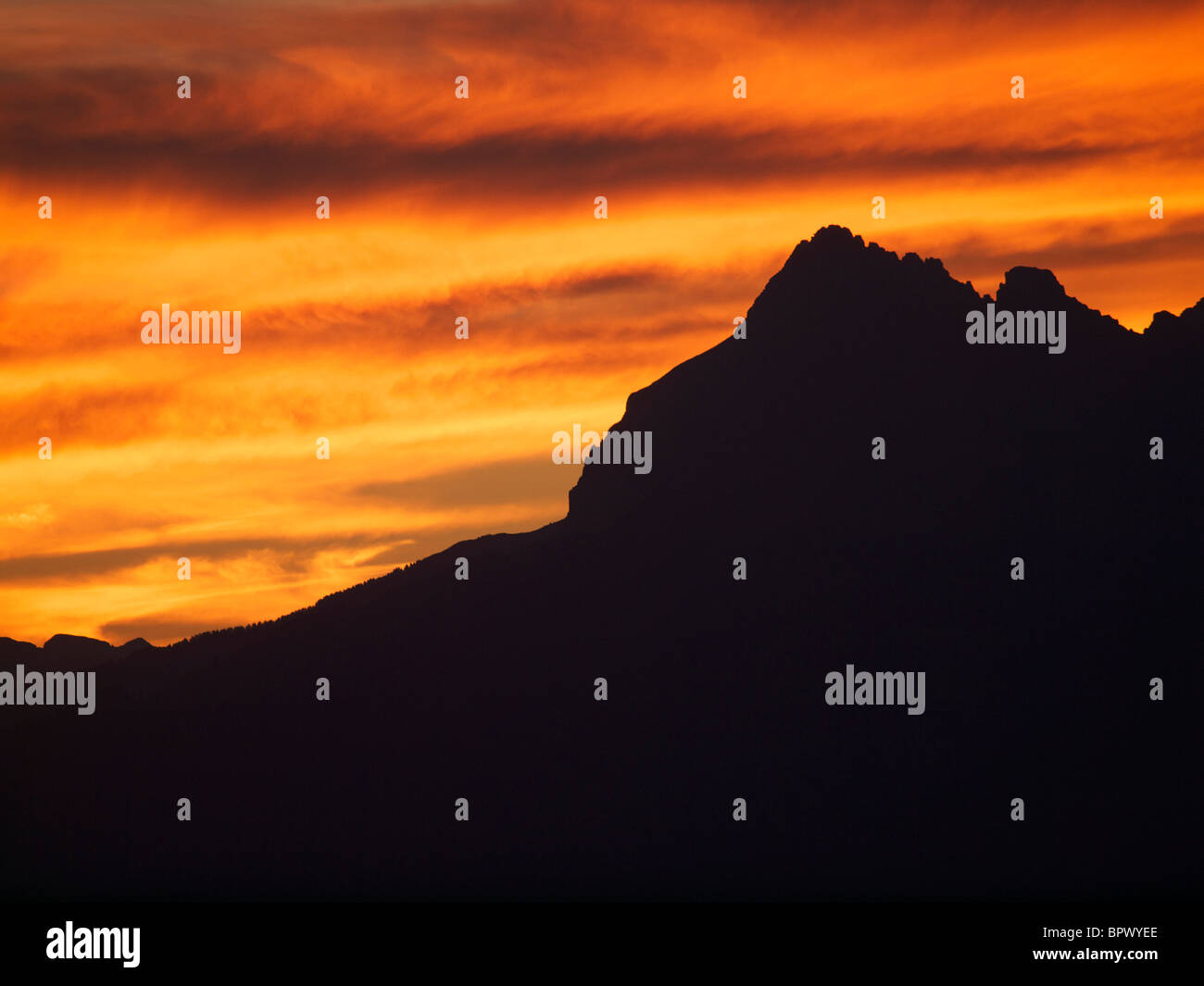 Puesta de sol en los Alpes con naranja brillante cielo Les Orres, Hautes Alpes, Francia Foto de stock