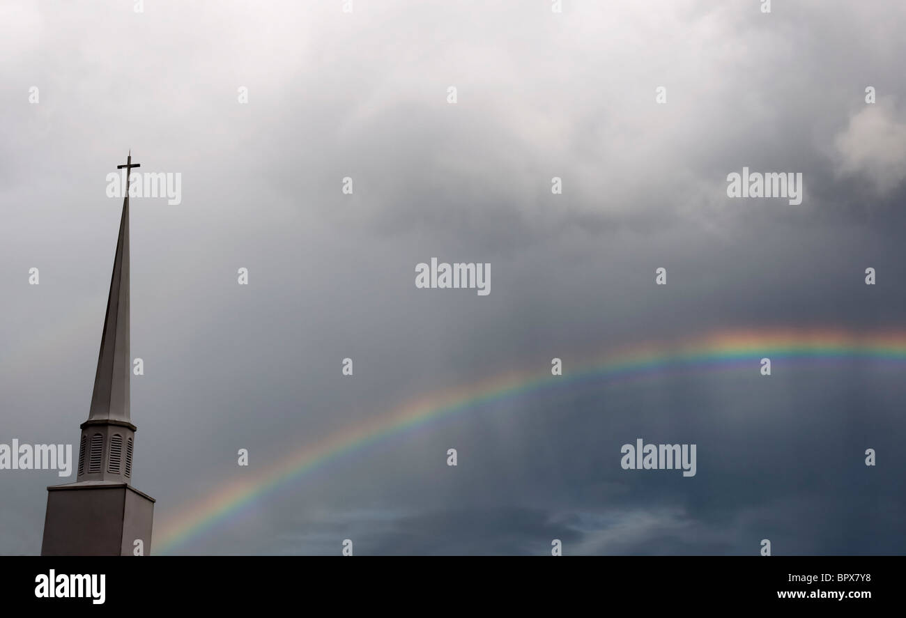 Campanario con arco iris en el cielo nublado tormentoso Foto de stock