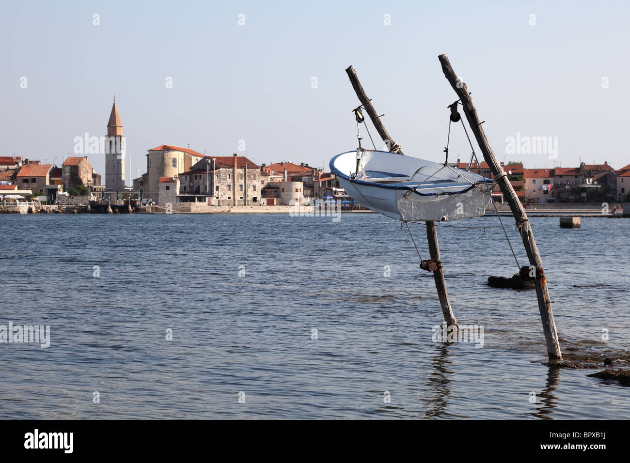 Barco pesquero que cuelga sobre el agua, la costa del Mar Adriático en Umag, Croacia Foto de stock