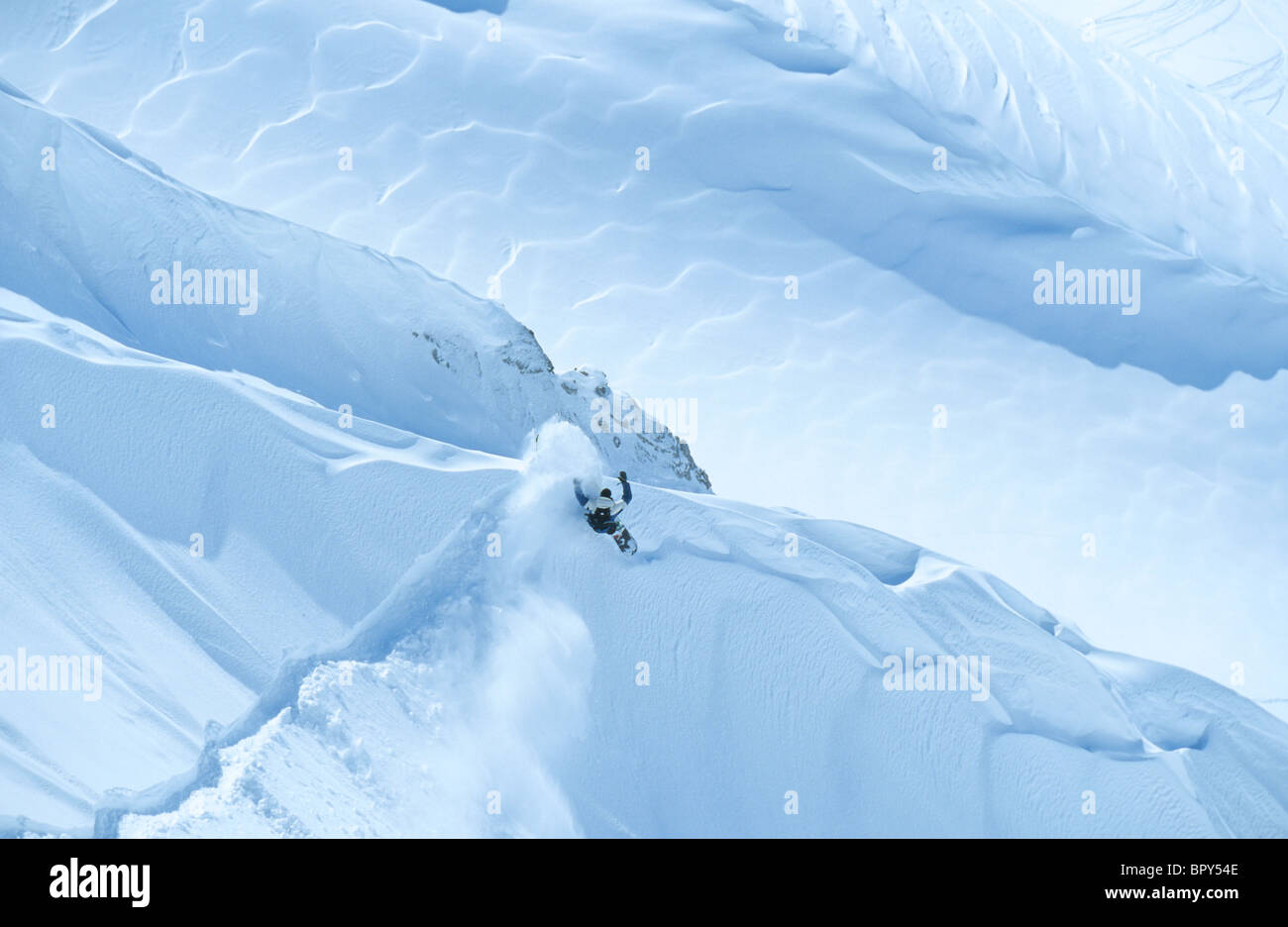 Snowboarder hace una diagonal en el polvo en Austria. Foto de stock