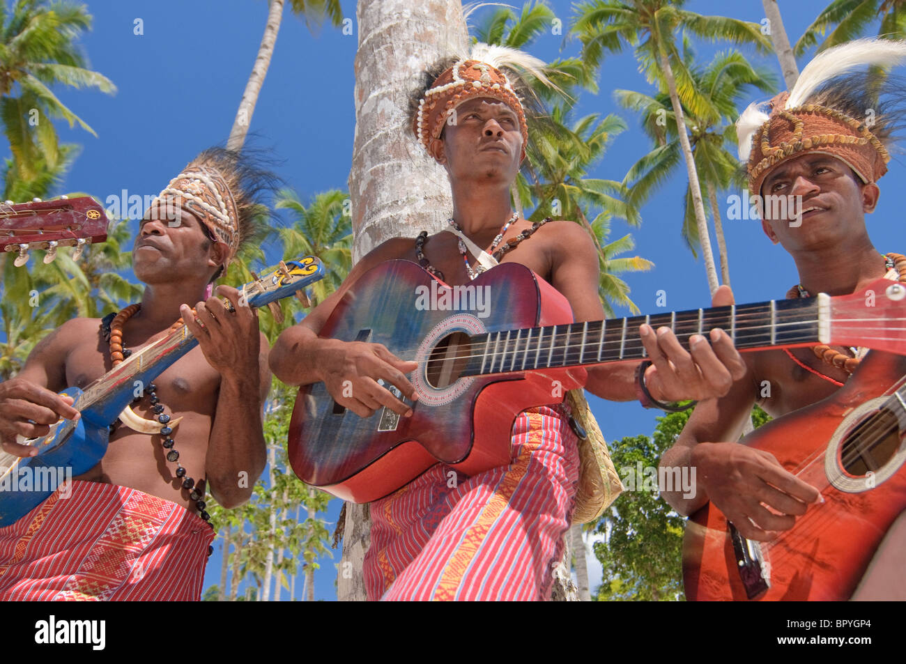 matrimonio Laboratorio División Tres nativos de Papúa jugando un instrumental con la playa de fondo y con  un tejido tradicional Fotografía de stock - Alamy