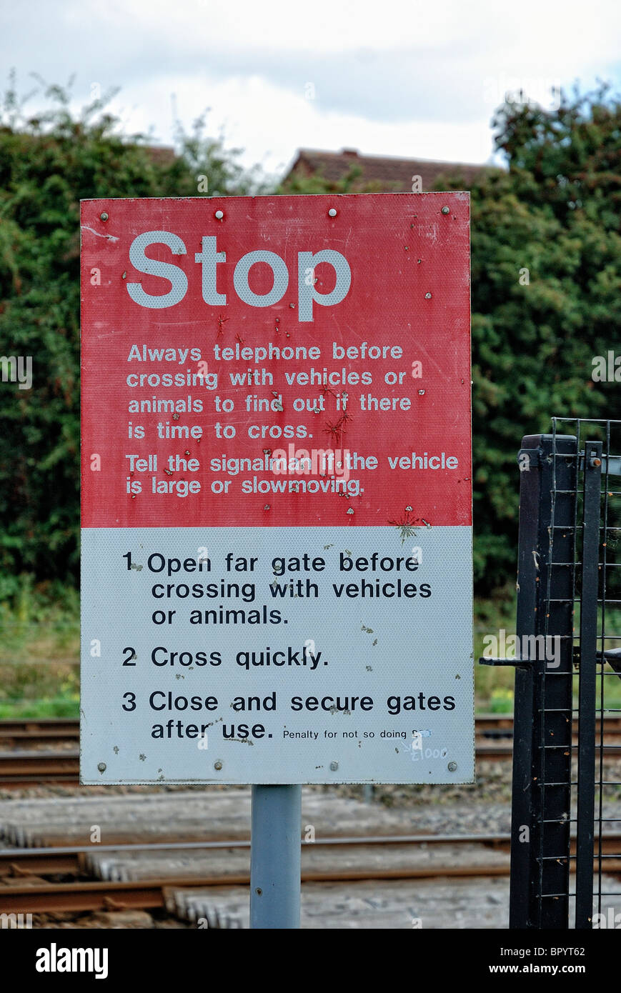 La señal de stop en el cruce gates junto a la línea ferroviaria Inglaterra Foto de stock
