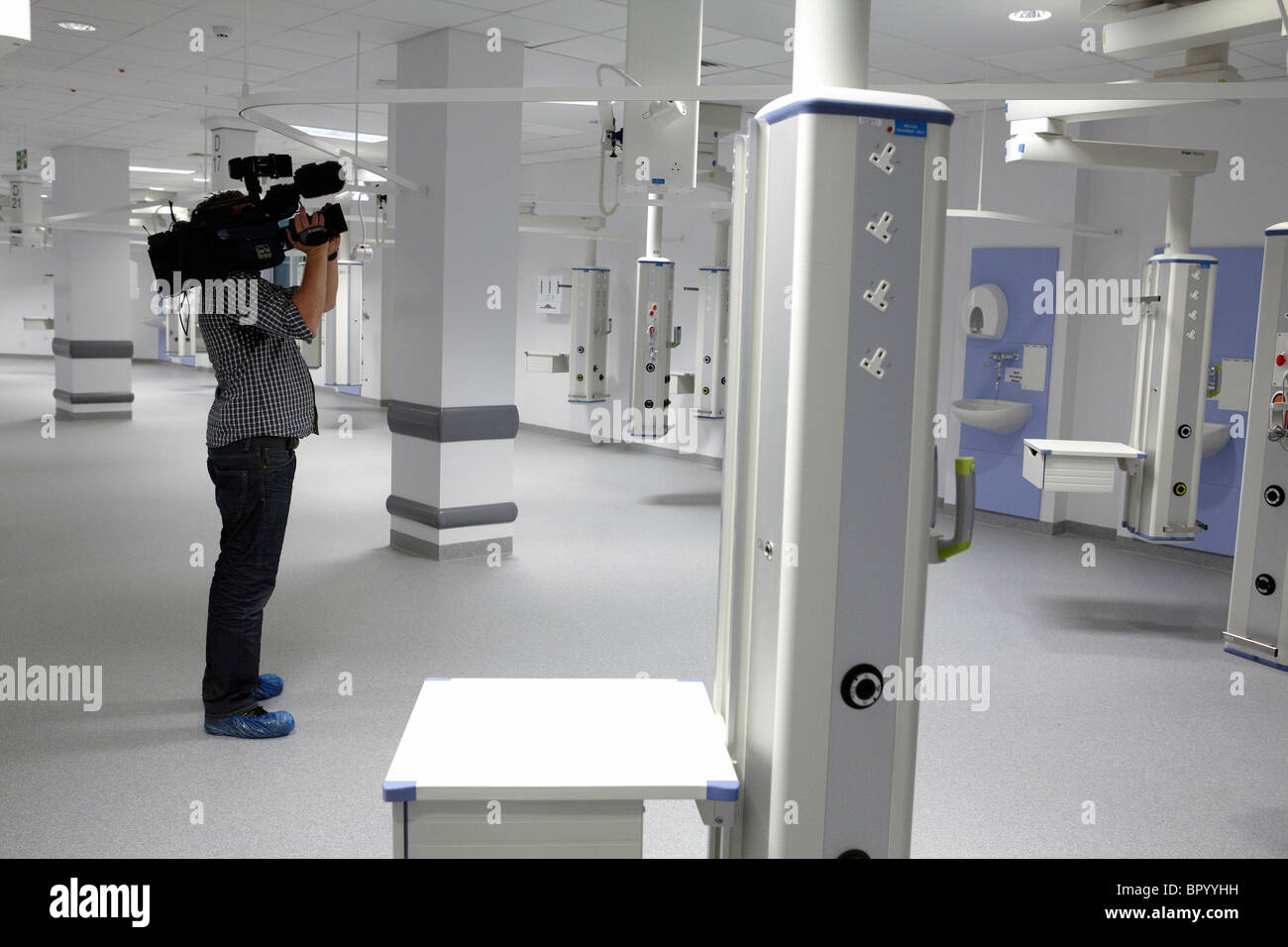 Un camarógrafo de televisión películas dentro de un nuevo hospital para las noticias de la TV. Foto de stock