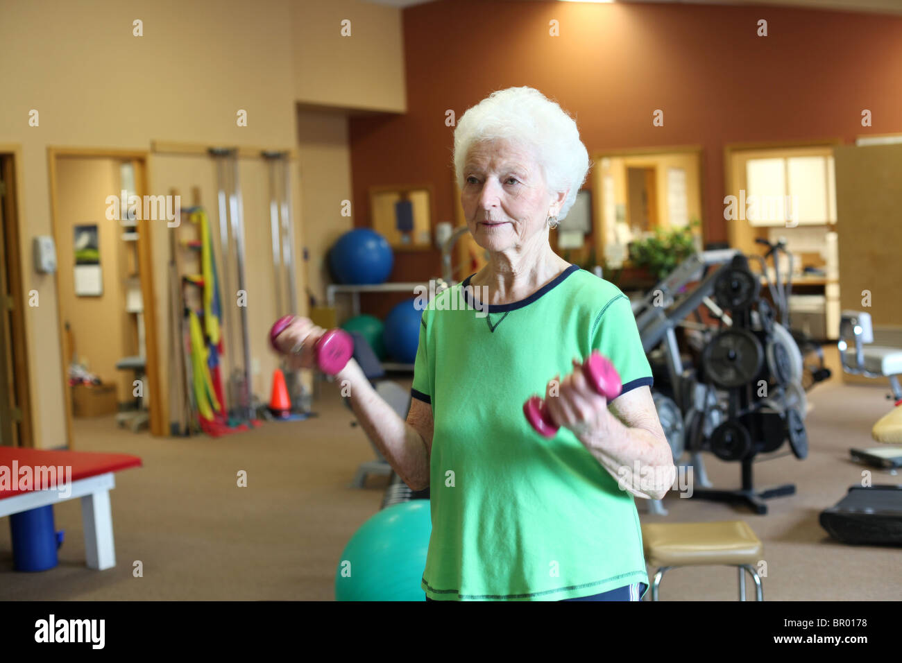 Mujer senior sano ejercicio con pesas en el gimnasio Foto de stock