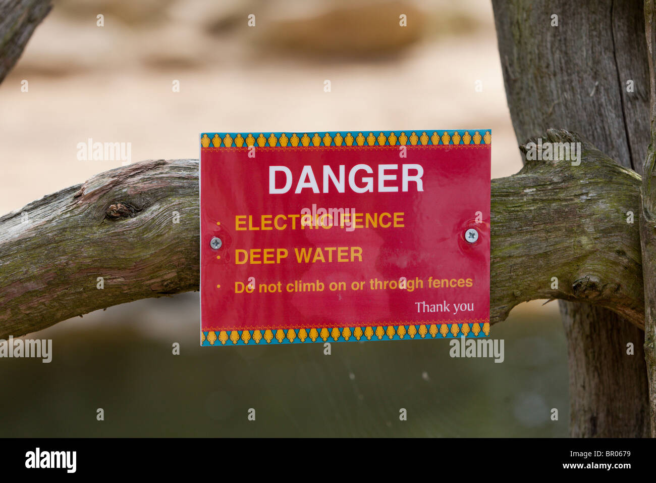 Signo de advertencia de un cerco eléctrico y aguas profundas. Foto de stock