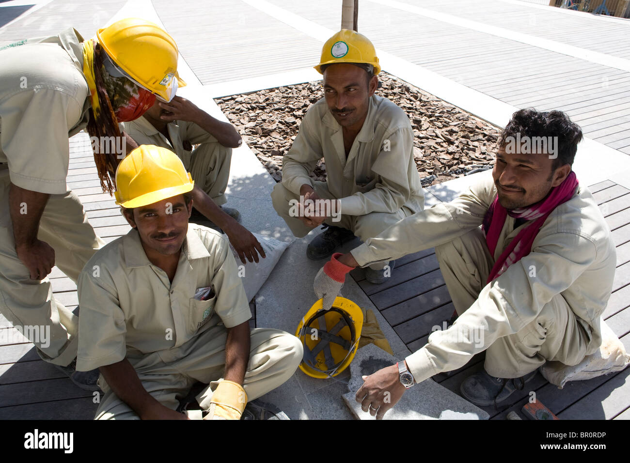Extraño los hombres están descansando durante su trabajo en el sitio de construcción en Dubai. Foto de stock