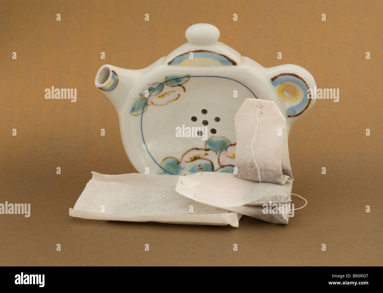 Soporte para teteras de té con orificios de drenaje en el mostrador con una pantalla de teabags de varias formas y tamaños. Foto de stock