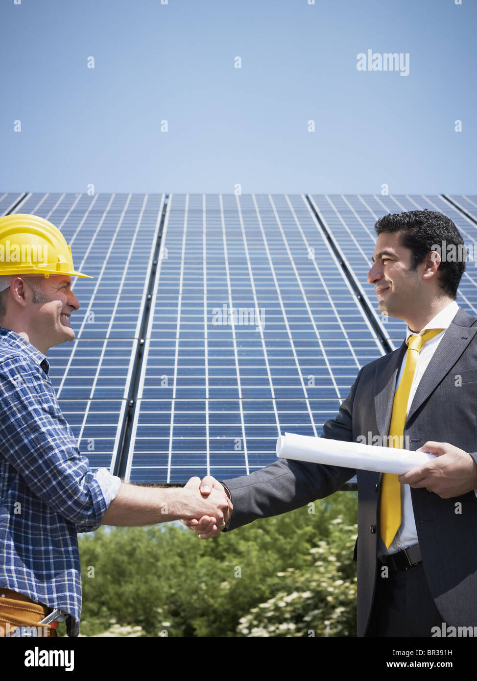 Un apretón de manos con el ingeniero empresario de estación de energía solar Foto de stock