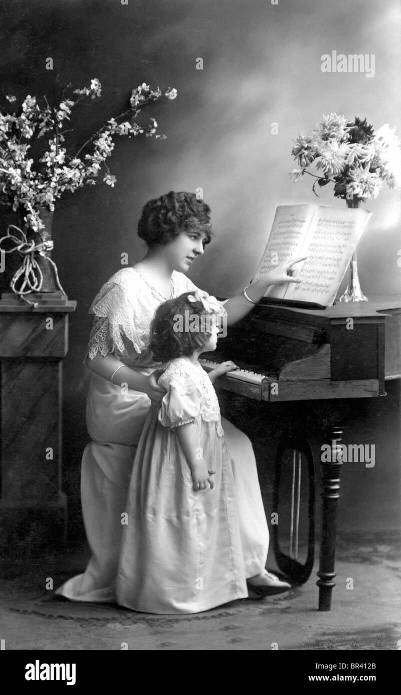 Imagen histórica, la madre y el niño en el piano, ca. 1912 Foto de stock