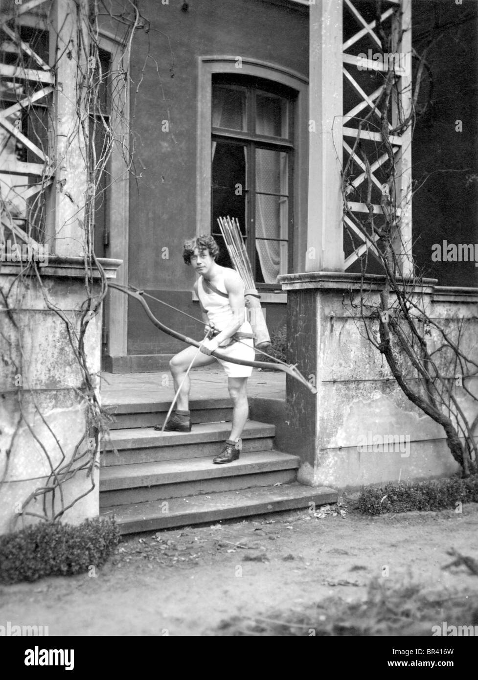 Imagen histórica, el niño con un arco y una flecha, ca. 1920 Foto de stock