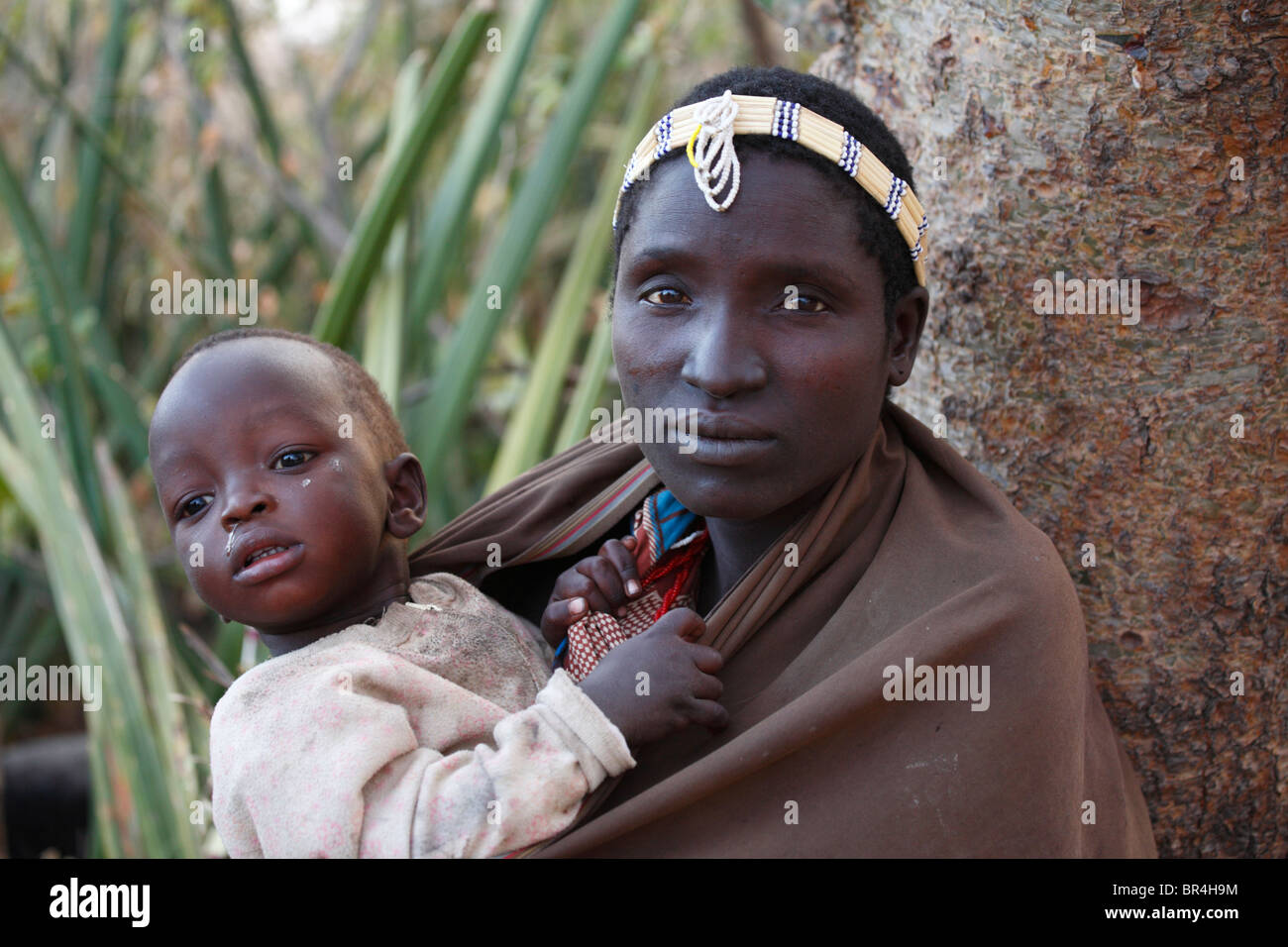 Hadza mujer con su niño, grupo étnico que vive en la zona del lago Eyasi, Tanzania Foto de stock