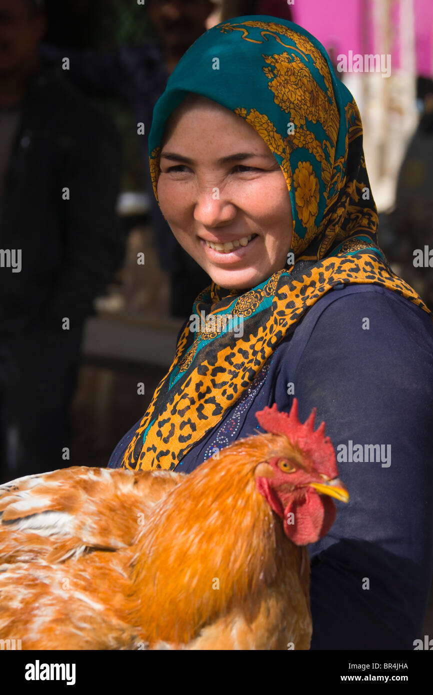 Mujer uigur con pollo, Hotan,, Xinjiang, China Foto de stock