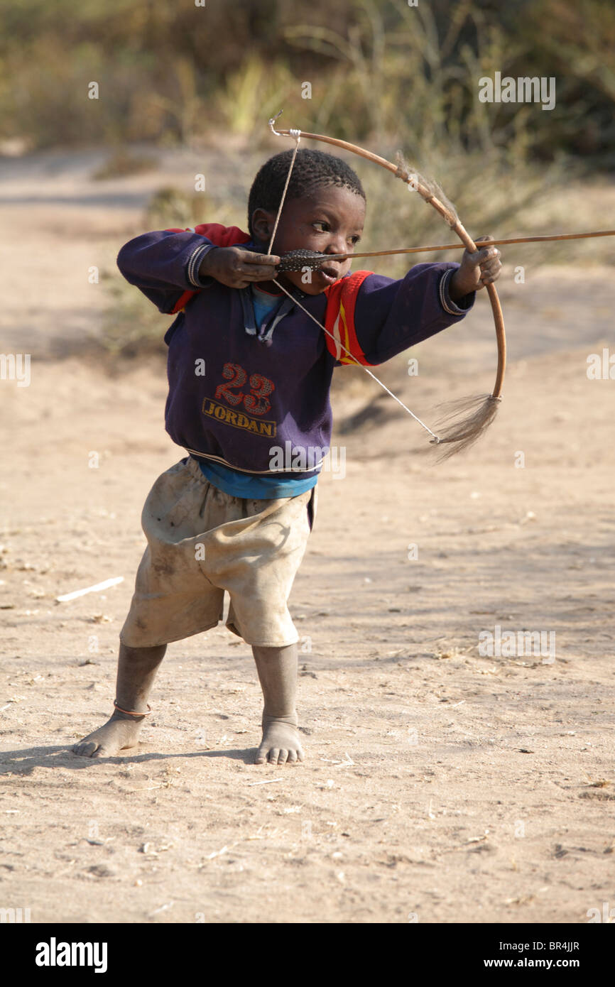 Hadza niño practicar arquería, Tanzania Foto de stock