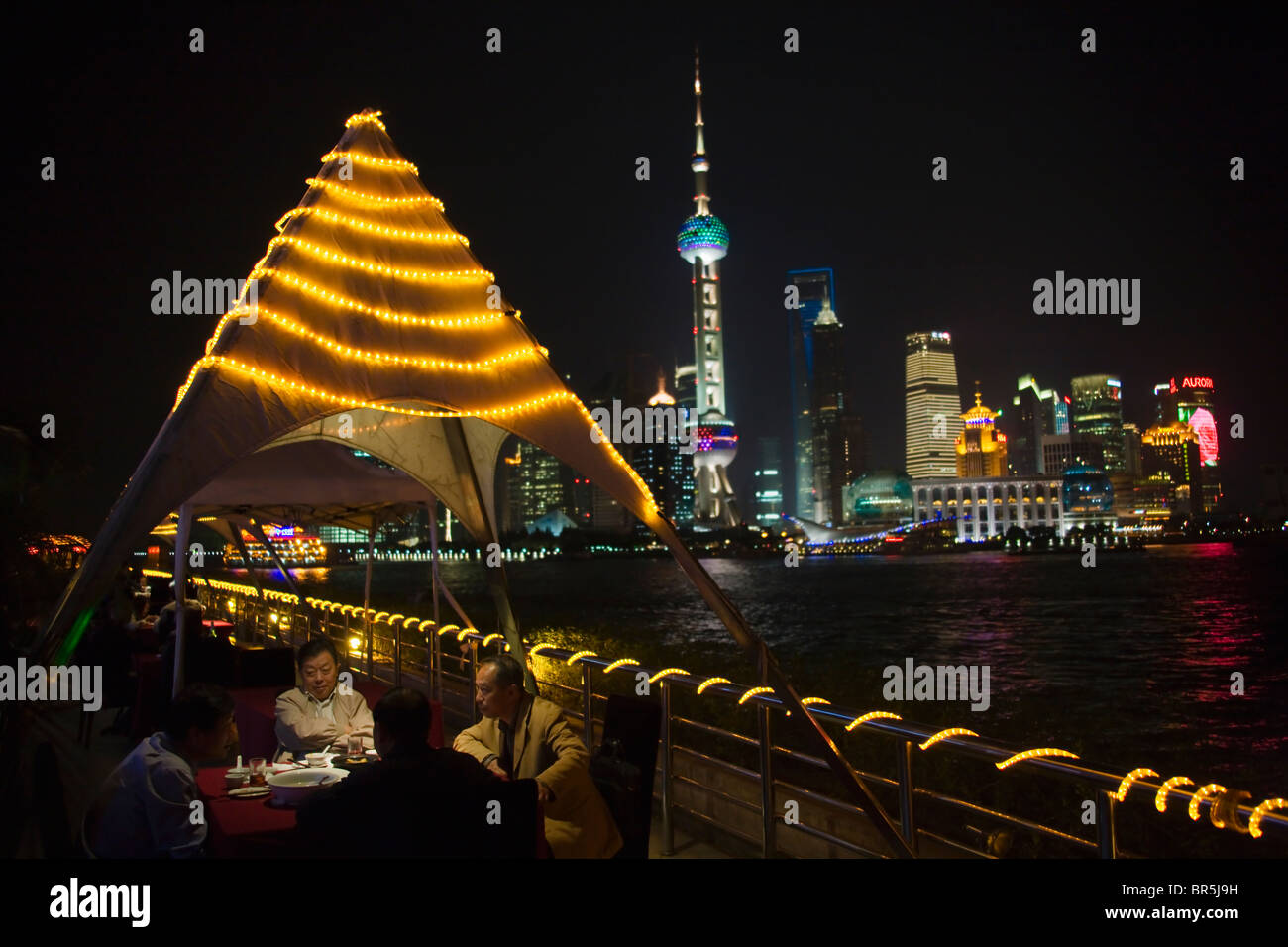 Vista nocturna de Pudong dominado por la torre de televisión Oriental Pearl a lo largo del río Huangpu, Shanghai, China Foto de stock