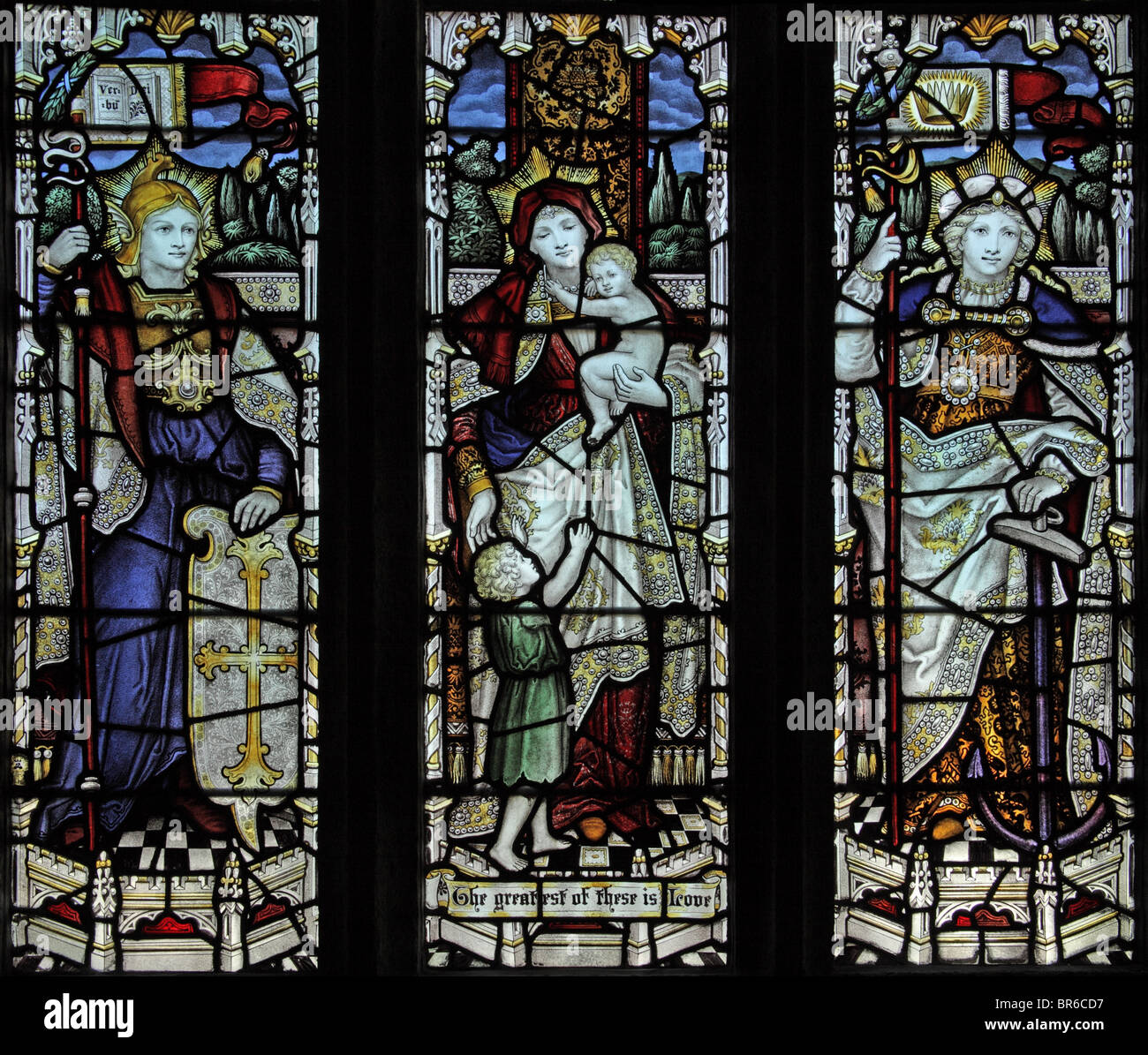 Una vidriera de C E Kempe & Co, 1907 que representa tres virtudes, Fe, Esperanza y Caridad, Iglesia Marhamchurch, Cornwall. Artista John Lisle Foto de stock