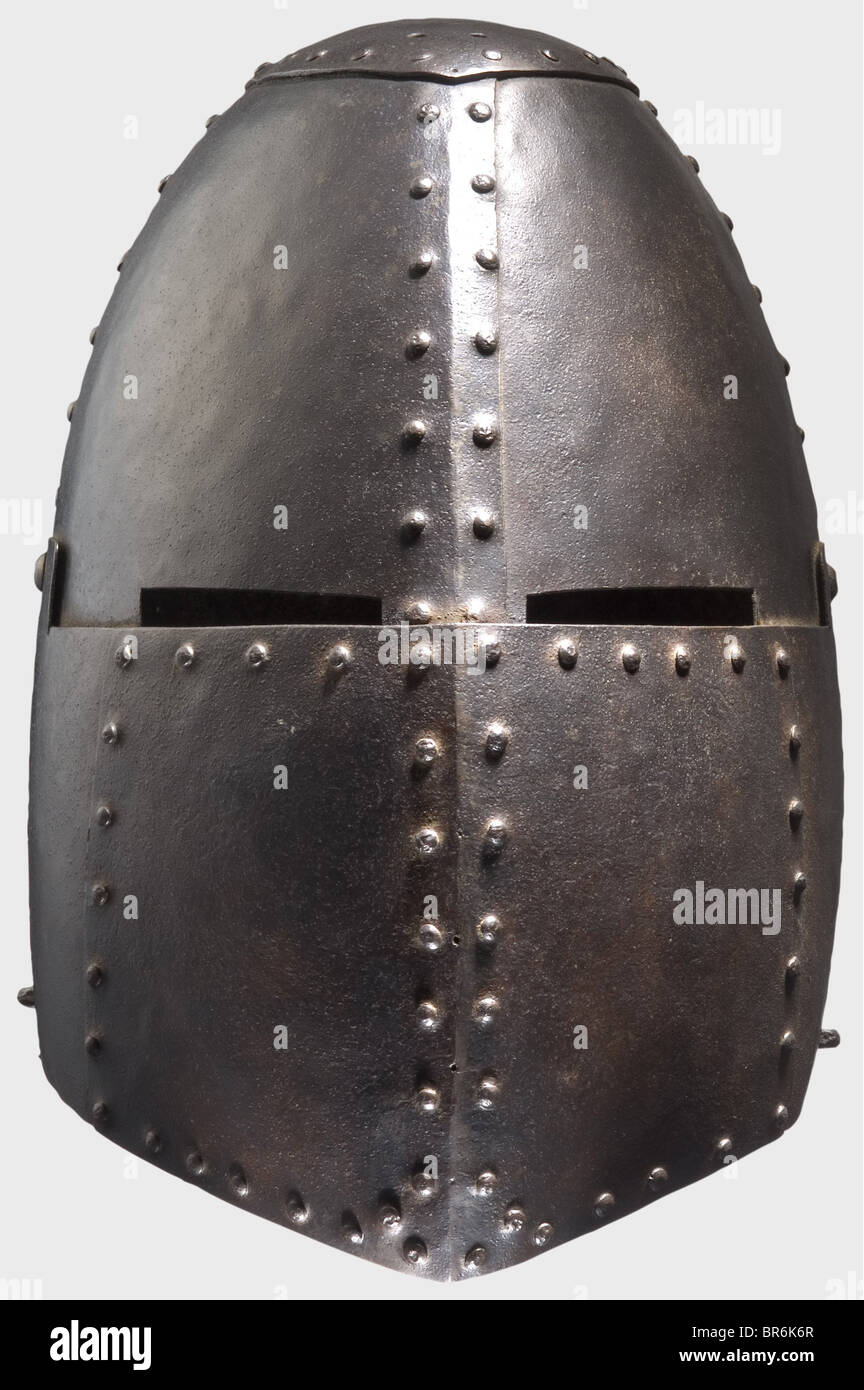 Un gran timón, Período de Historia en el estilo de la primera mitad del siglo 14. Casco hecho de varias piezas de placas de hierro remachadas. Pieza ovalada de corona con cuatro orificios dobles para fijar la cresta. Cráneo de cuatro piezas con una abertura de doble ojo. Visera móvil con un pestillo en el lateral. Una grapa en ambos lados para las correas. Altura 32 cm. Histórico, histórico, siglo 19, armas defensivas, armas, armas, arma, brazo, dispositivo de lucha, objeto, objetos, alambiques, recortes, recortes, recortes, recortes, utensilio, pieza de equipo, utensilios, chapado, blindaje-chapado, Foto de stock