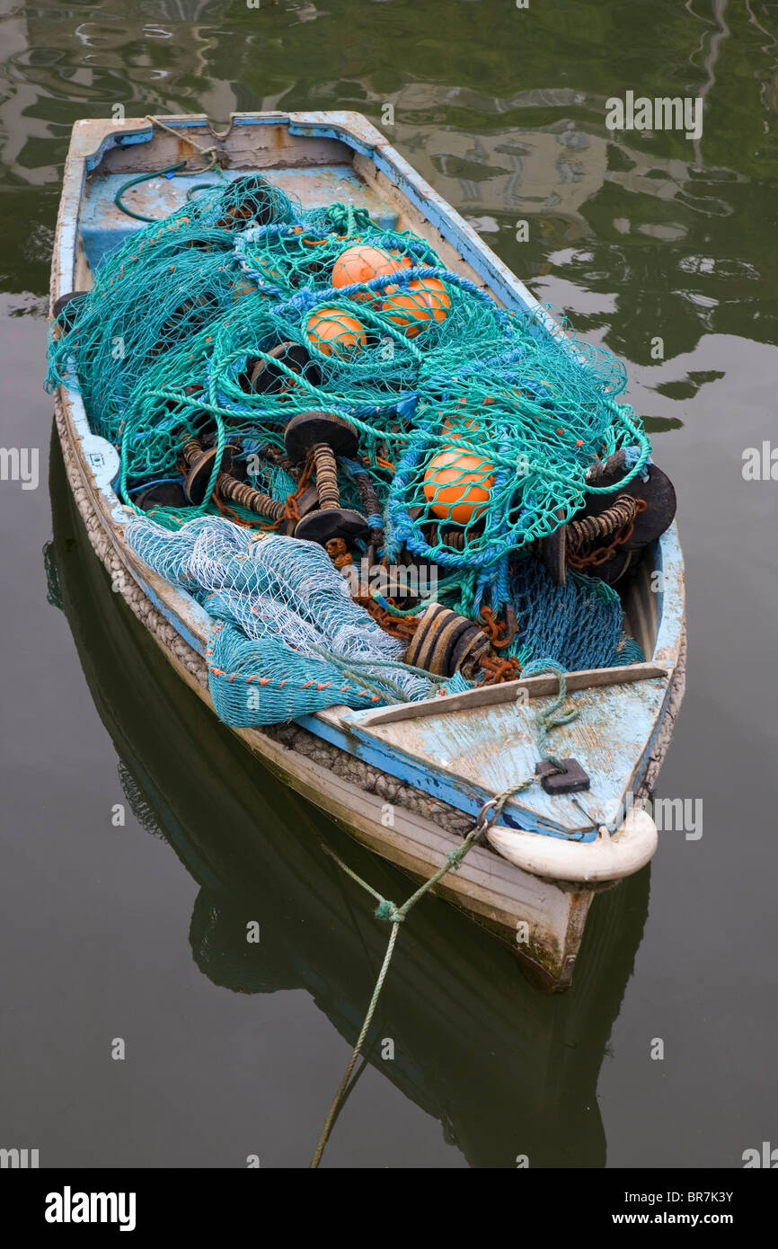 Pequeño barco pesquero lleno de redes de pesca y otros aparejos de pesca amarrados en Polperro Harbour Cornwall UK Foto de stock