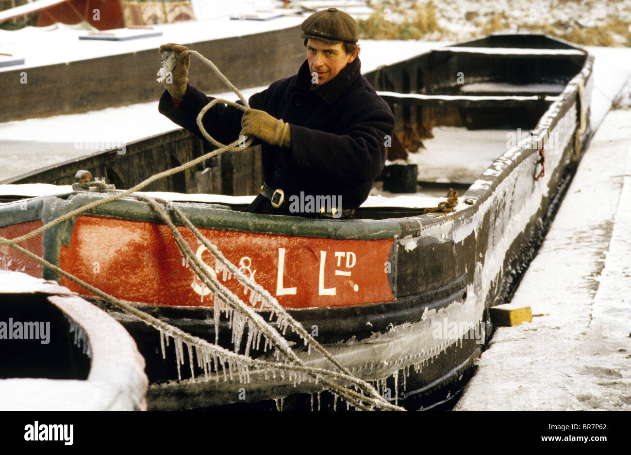 El hombre la desvinculación de cuerdas sobre narrowboat congelada en Black Country Museum Foto de stock