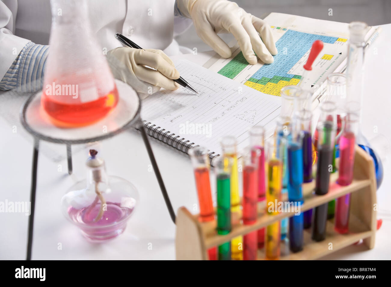 Reactivos en matraces, un cuaderno y un bolígrafo sobre una mesa en un  laboratorio químico Fotografía de stock - Alamy