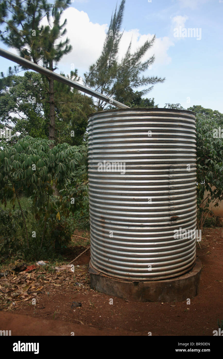 La recolección de agua de lluvia del techo a través de canales y tuberías desde un techo a un depósito de agua, zona rural de Uganda. Foto de stock