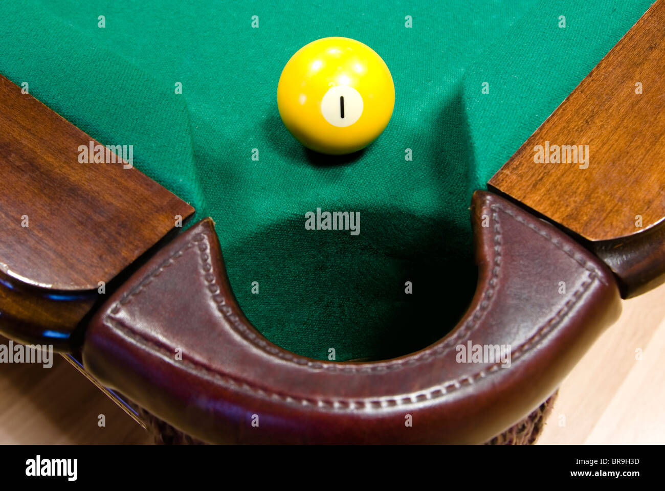 Bola de billar de color amarillo con el número '1' delante de una esquina  de bolsillo en la mesa de tapete verde Fotografía de stock - Alamy