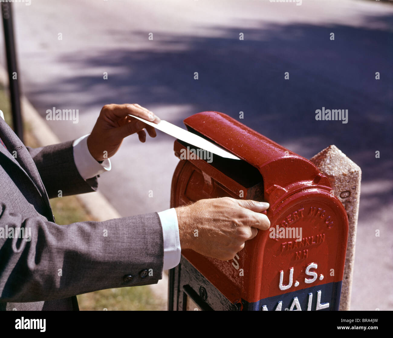 1960 Hombre mano bajando carta al buzón postal de EE.UU. Hombre carta postal Foto de stock