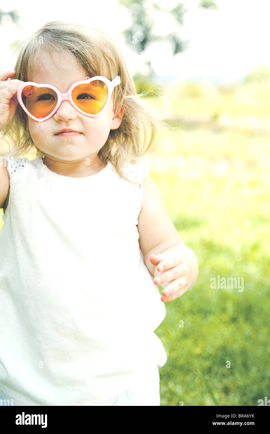 Muchacha con gafas de sol en forma de corazón Foto de stock