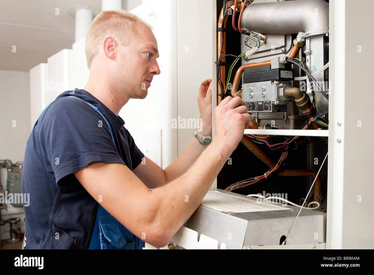 Calefacción y técnico sanitario comprobación y ajuste de un calentador de gas Foto de stock