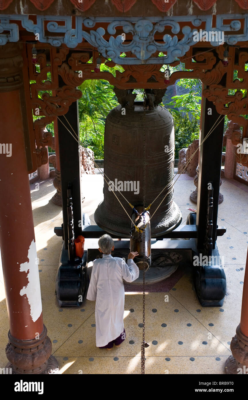 Nun sonando una campana gigante, Pagoda Long Son, Vietnam, Indochina, en el sudeste de Asia, Asia Foto de stock