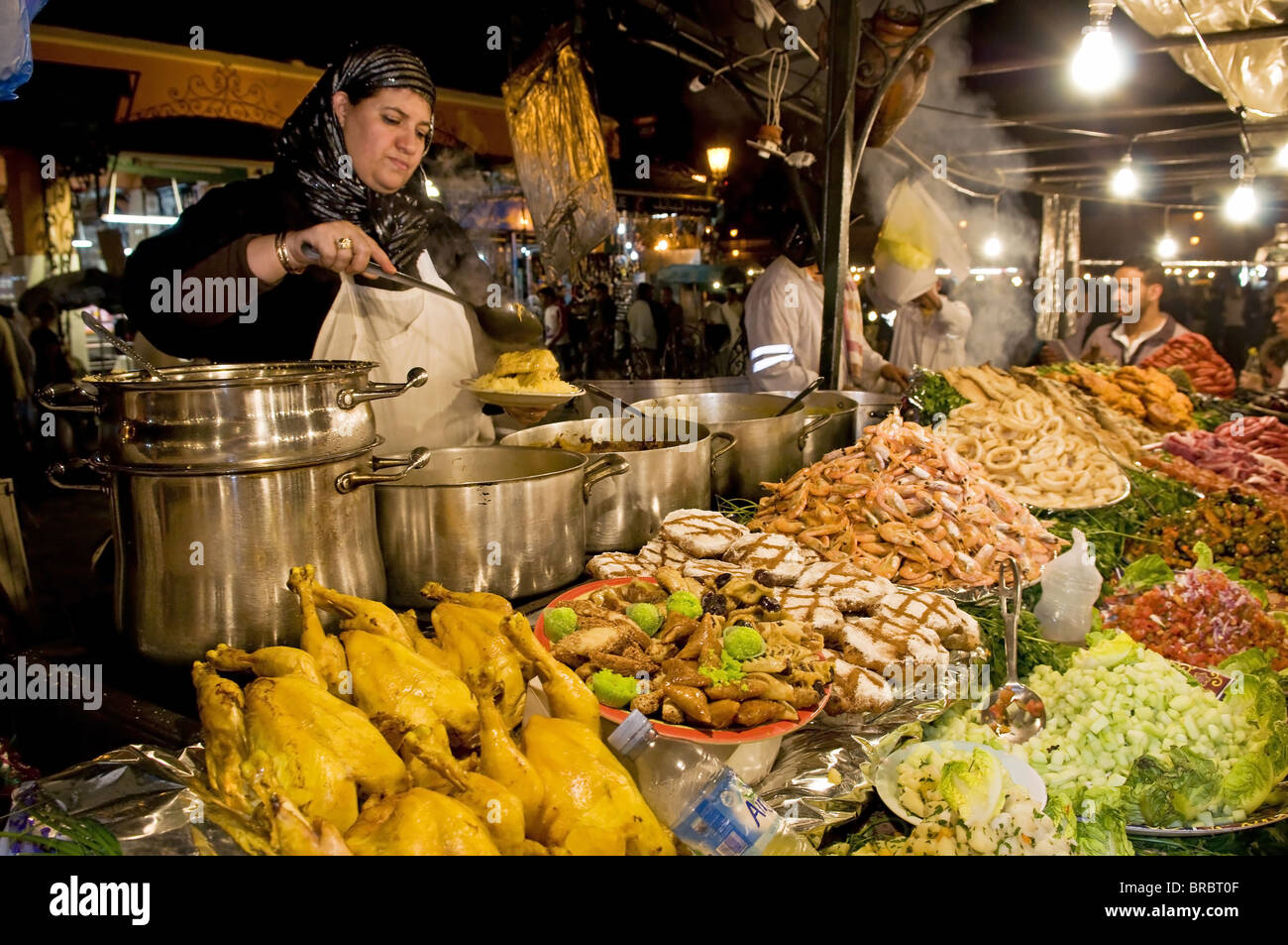 Cocinar los alimentos de venta desde su puesto en la plaza Djemaa el Fna (lugar) de Jemaa El Fna en Marrakech, Marruecos, Norte de África Foto de stock
