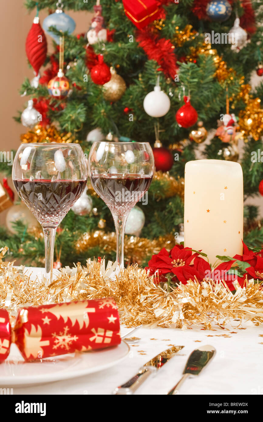 Mesa de comedor con galletas navideñas, y decoraciones en frente de un árbol de navidad Foto de stock