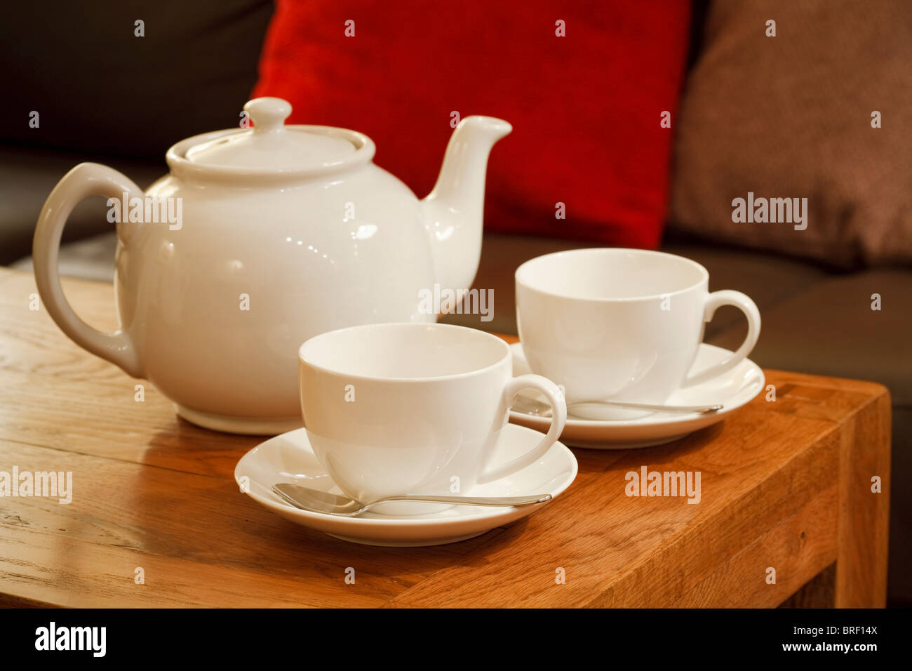 China blanca tetera y tazas con platillos en el salón de una casa moderna Foto de stock