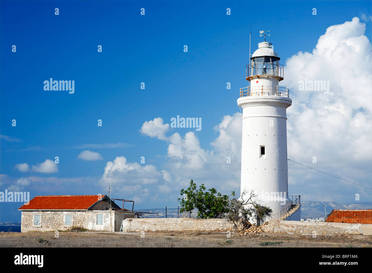 Faro, casa blanca, techo rojo, azul cielo, nubes blancas, Pafos, Pafos, Chipre, Europa Foto de stock
