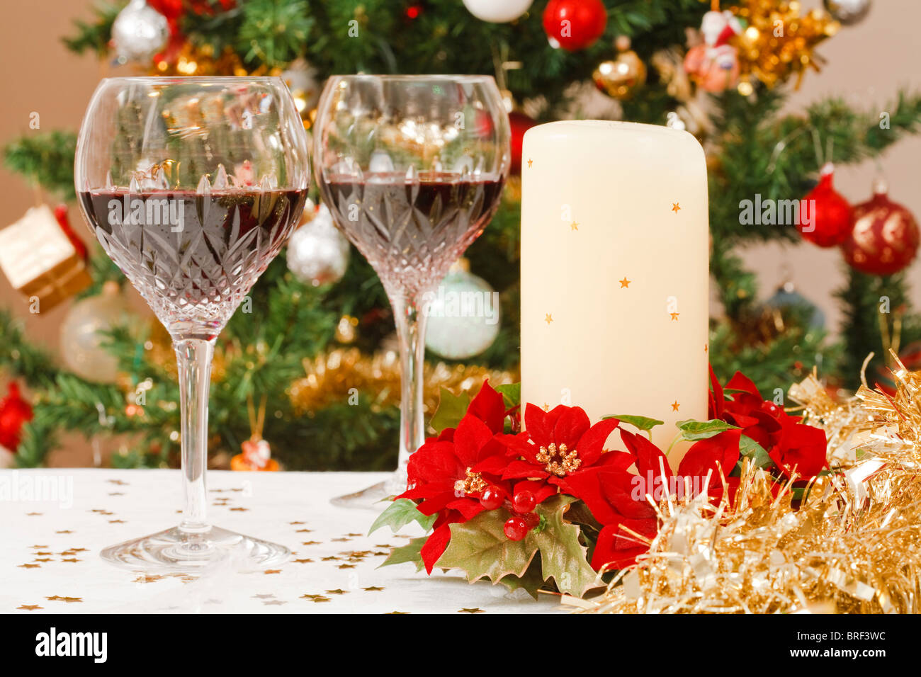 Escena con árbol de Navidad comedor de cristal, copas de vino y decoración de la mesa navideña Foto de stock