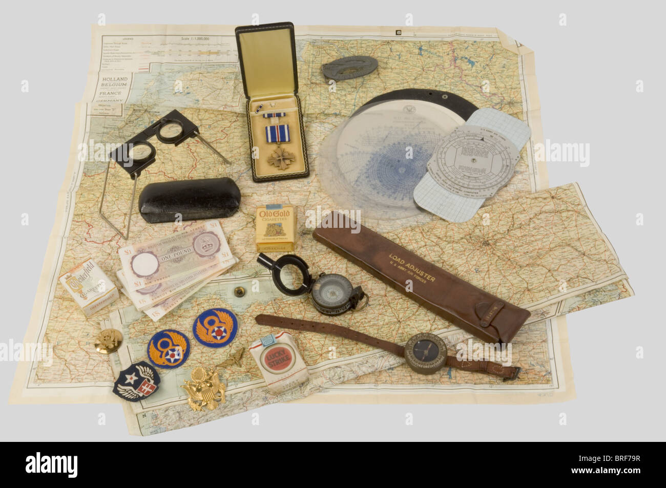 Etats Unis Deuxième Guerre Mondiale, Ensemble de souvenirs de l'US Air  Force, comprenant une 'DFC' dans sa boîte, plusieurs insignes métalliques,  une règle de calcul dans son étui cuir, une sole de