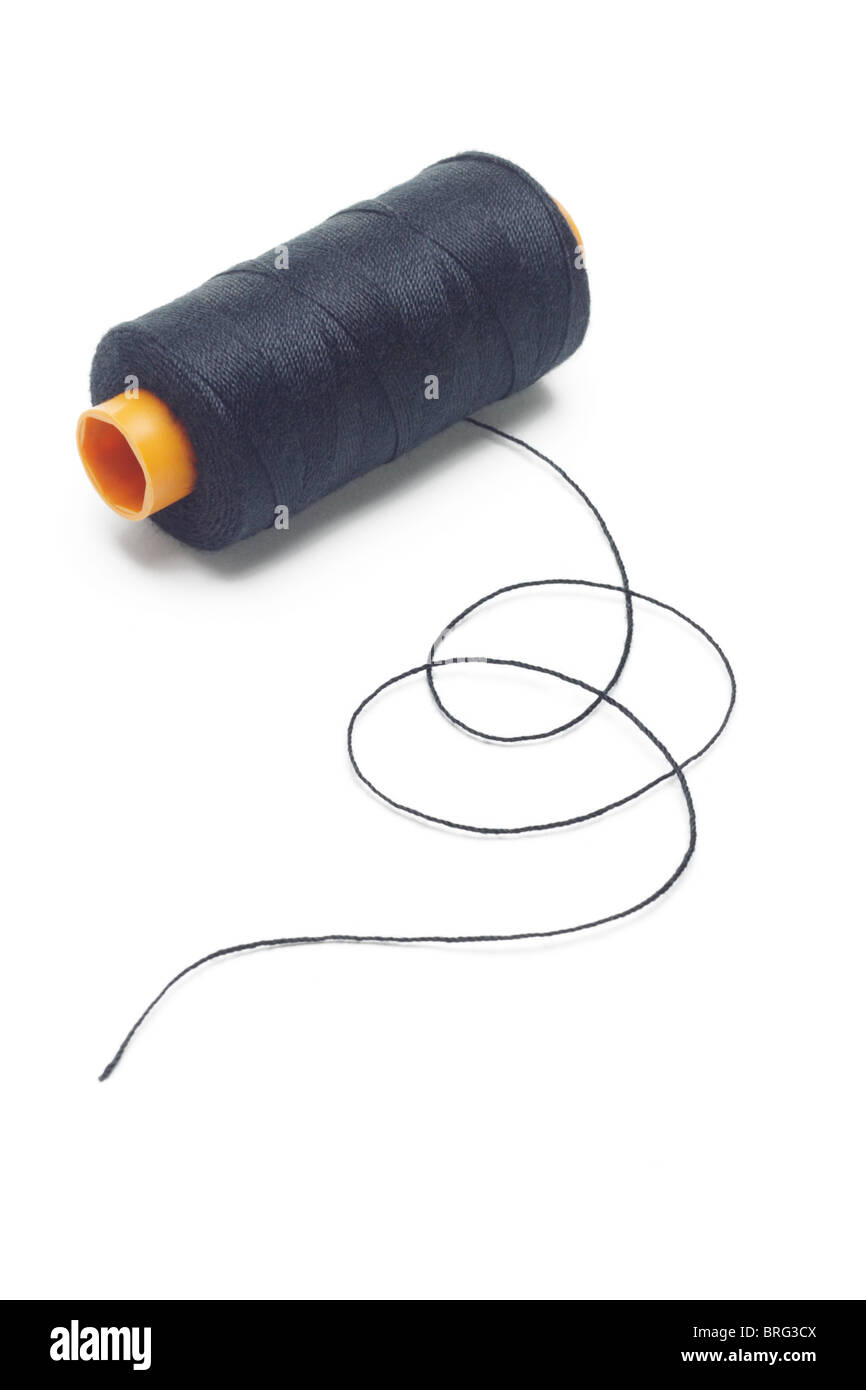 Bobina de hilo de algodón negro sobre fondo blanco. Foto de stock