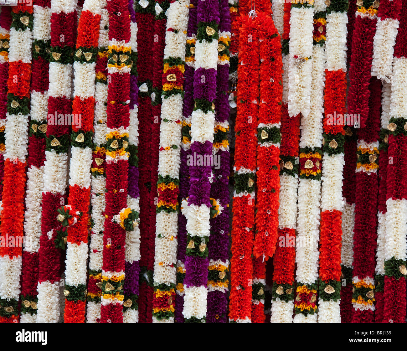 Imitación guirnaldas de flores utilizados en el culto religioso hindú en un puesto en el mercado en la India Foto de stock