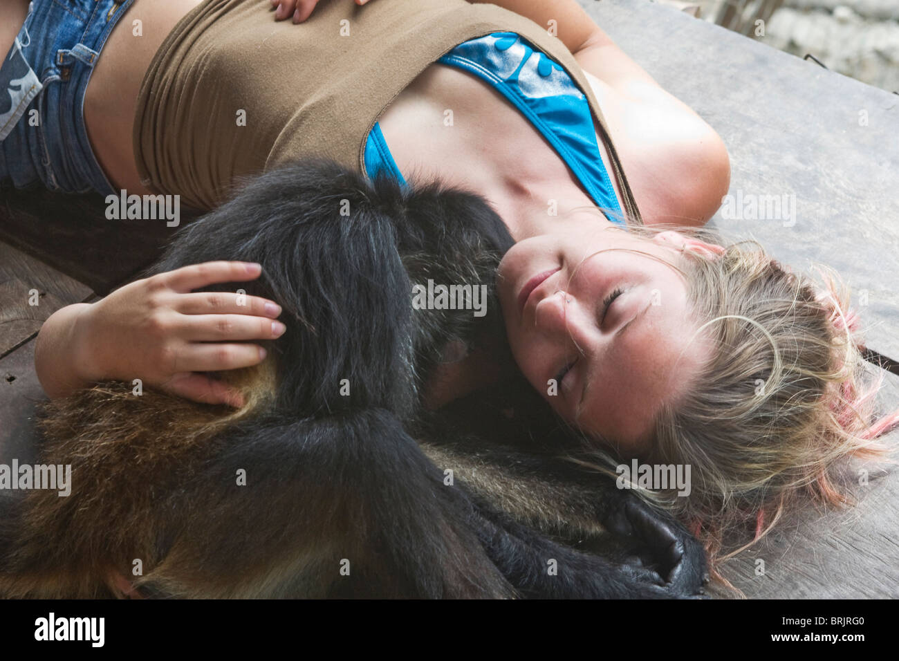 Mujer abraza con mono en México. Foto de stock