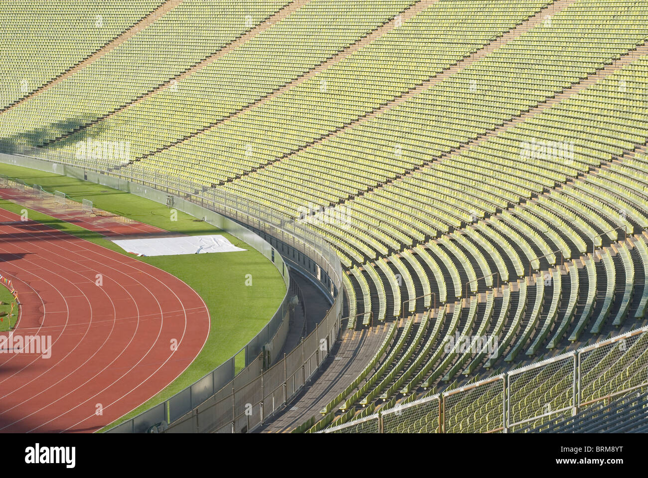 El estadio de atletismo con filas de asientos vacíos y Vía Foto de stock