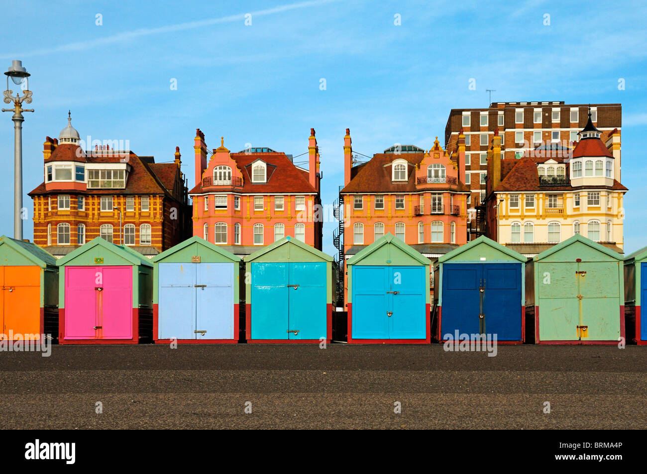 Coloridas casetas de playa y edificios a lo largo del paseo marítimo de Hove mar, Brighton & Hove, East Sussex, Reino Unido Foto de stock