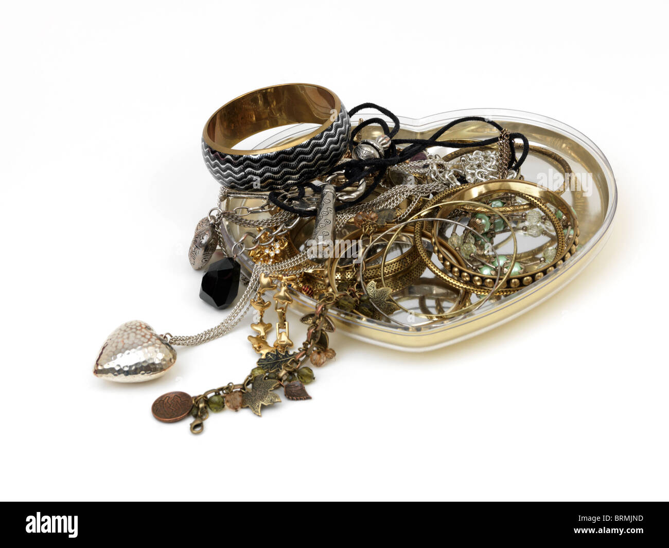 Montón de joyas en una bandeja de corazón de plata Foto de stock
