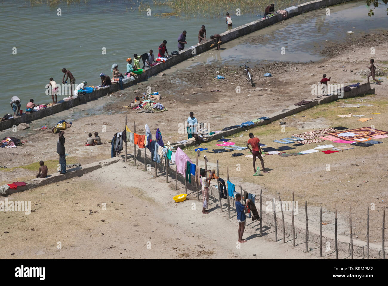 Los lugareños se reunieron en el lago Awassa para hacer su lavado con coloridas prendas colgadas en una valla para secar Foto de stock