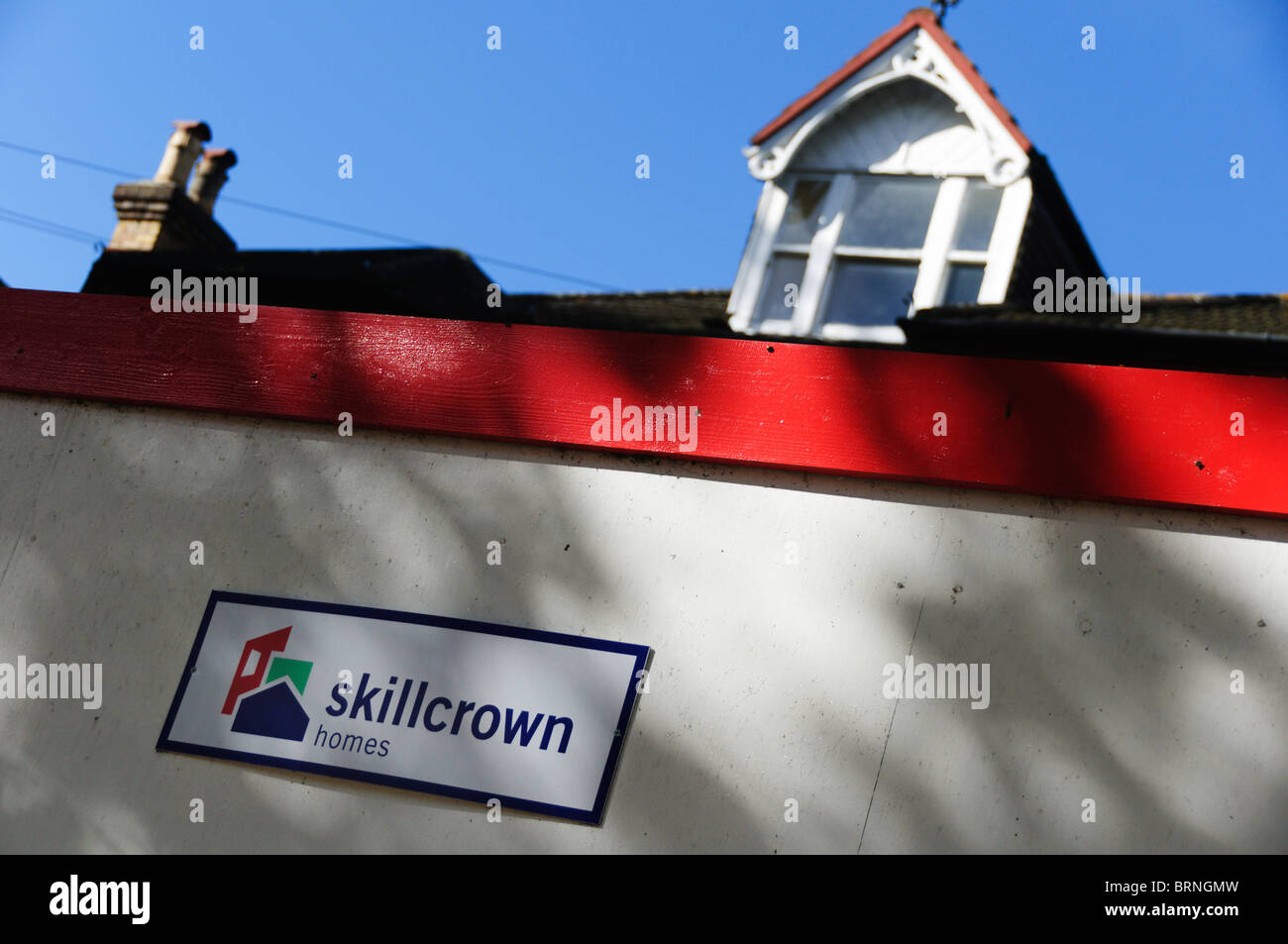 El acaparamiento de un sitio alrededor de una casa que lleva el nombre y el logotipo de Skillcrown casas. Foto de stock