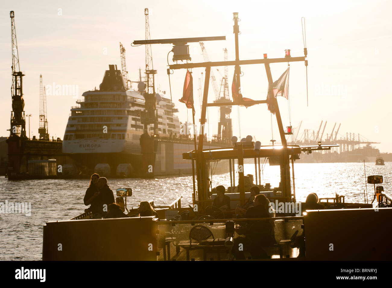 Alemania Hamburgo, puerto fluvial con ferry y astillero Blohm y Voss con crucero Europa de Hapag Lloyd naviera empresa en muelle flotante Foto de stock