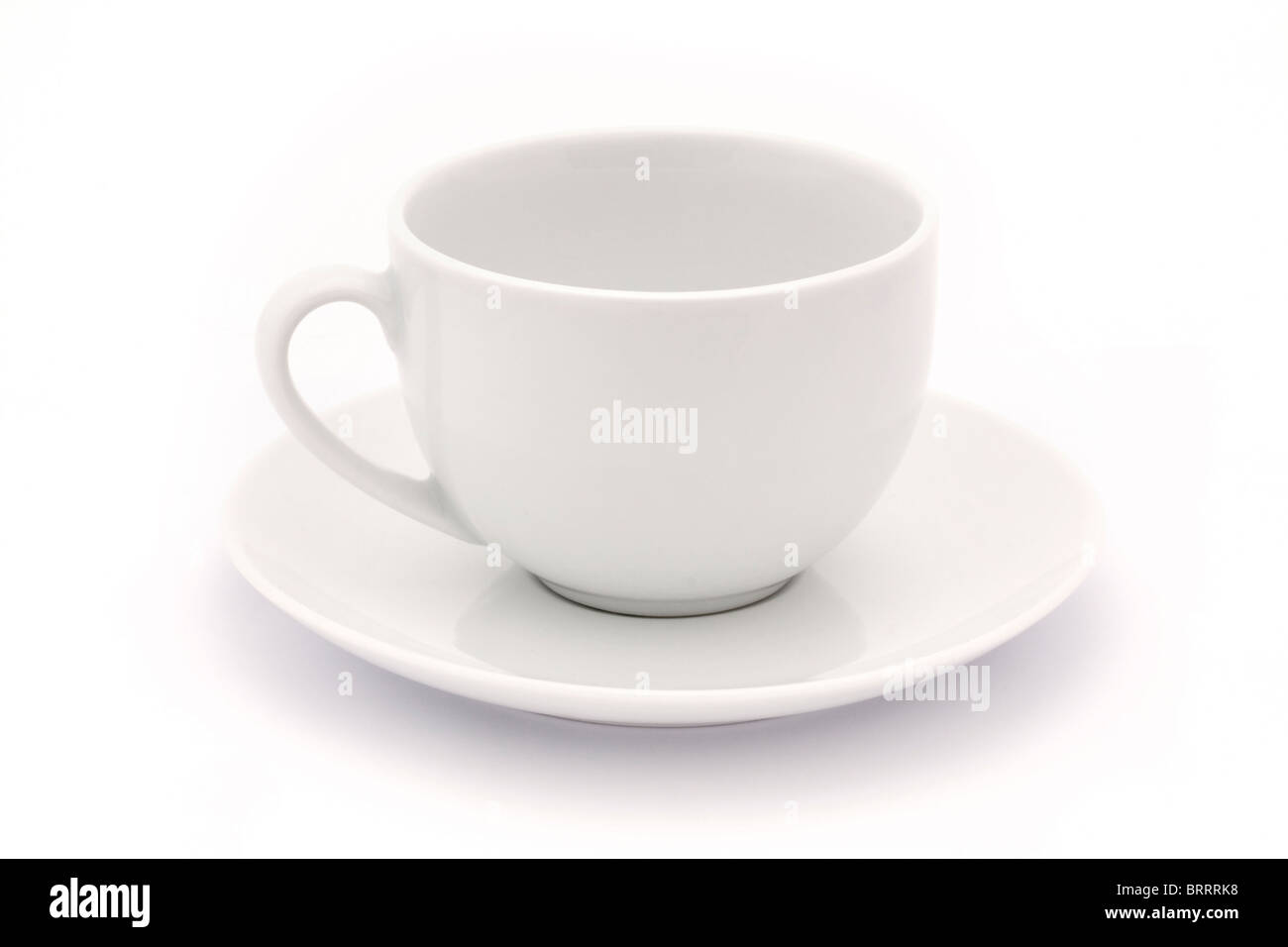 Vacía taza y plato de té blanco sobre blanco Foto de stock