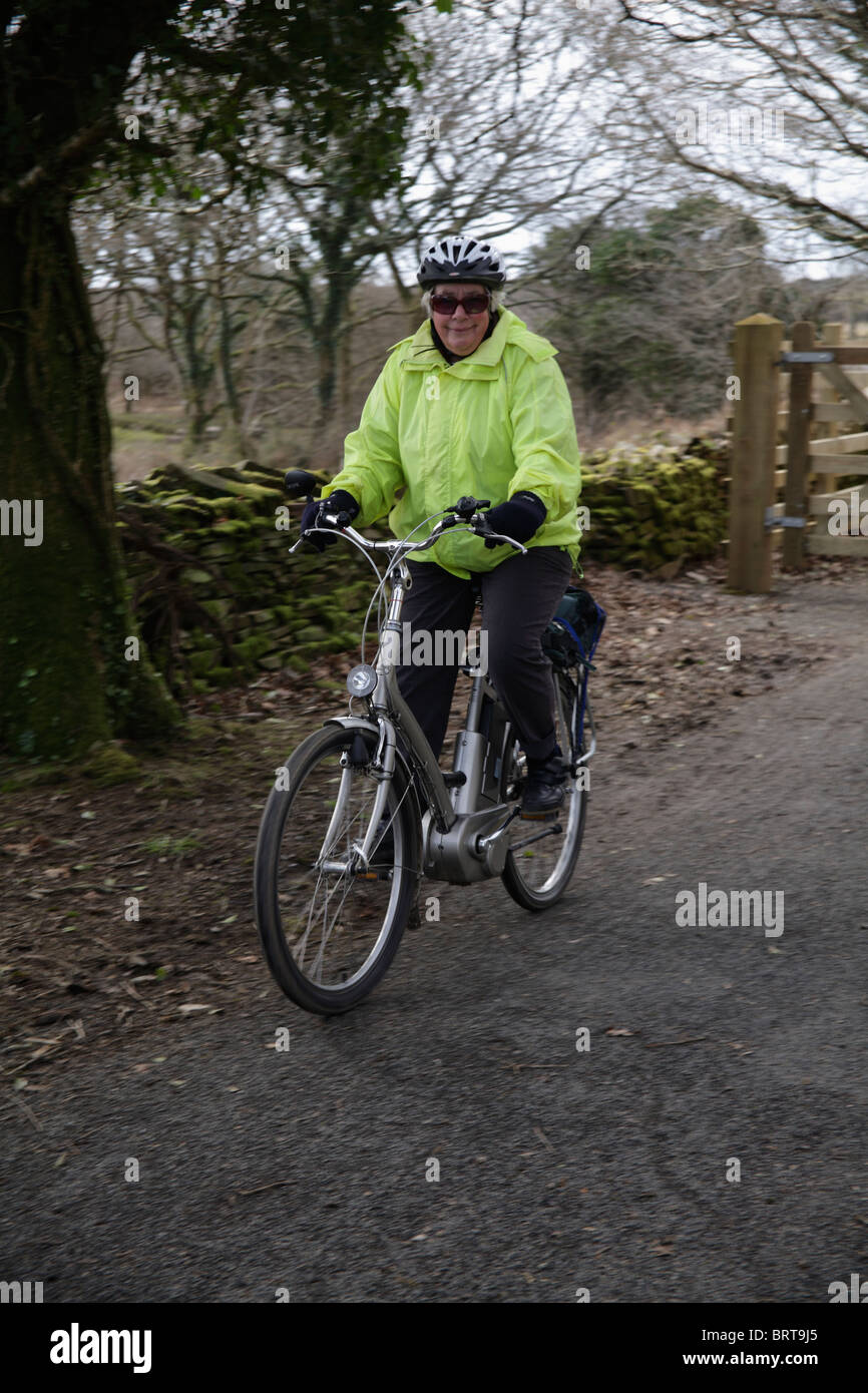 Ancianos dama senior montando bicicleta eléctrica asistida eléctricamente gigante en la ruta 27 cycleway Sustrans cerca de Yelverton Devon UK de stock - Alamy