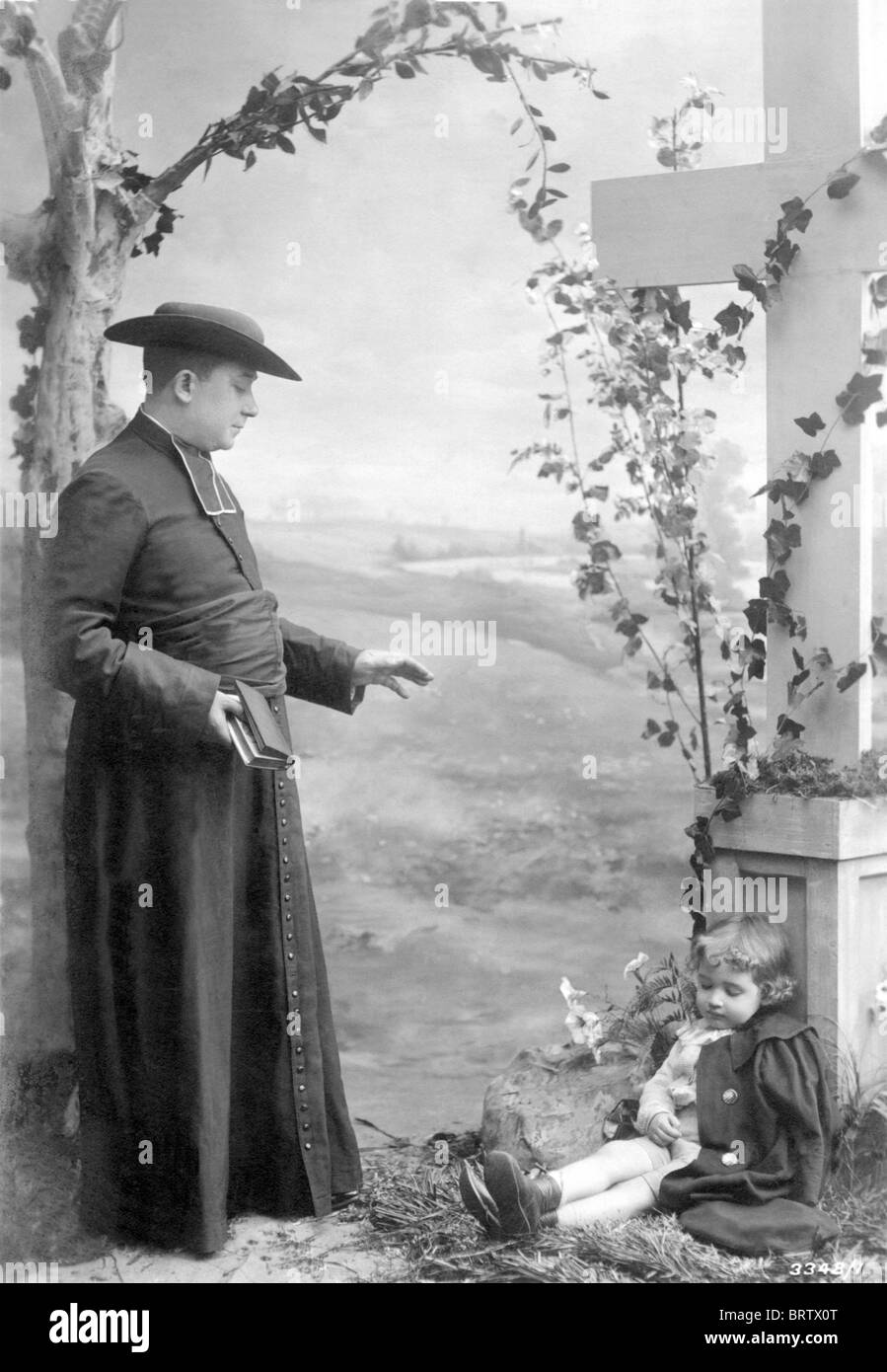 Sacerdote con el niño, imagen histórica, ca. 1924 Foto de stock