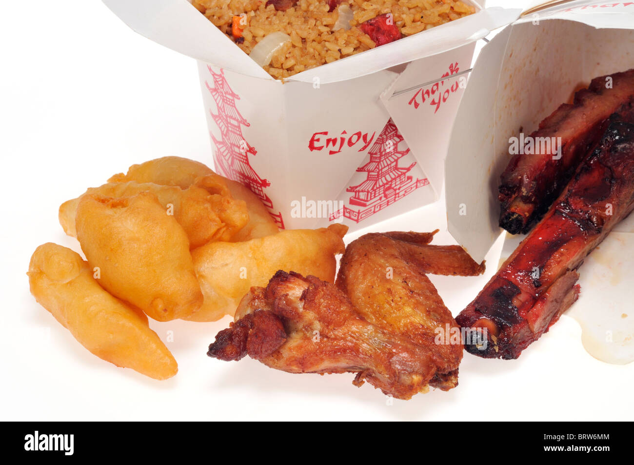 Comida china para llevar comida cajas o cartones de cerdo fritos arroz con pollo dedos, alas de pollo y costillas de cerdo sobre fondo blanco. Foto de stock