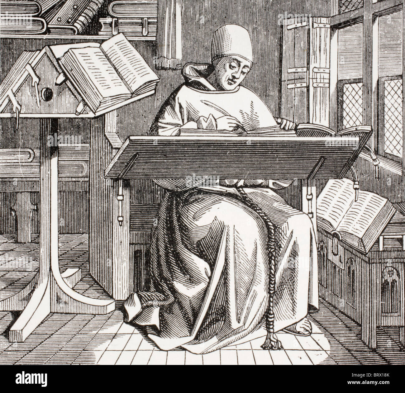 Un monje escribano escrito en su escritorio, rodeado de manuscritos y libros . Foto de stock