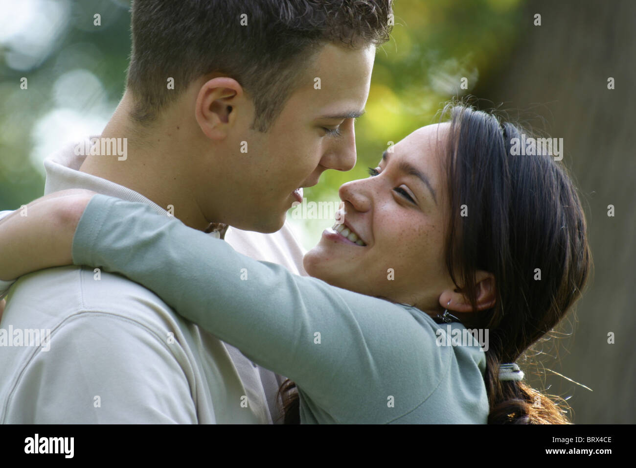 Romance adolescente, joven asiática abrazando a su novio fuera y una sonrisa. Foto de stock